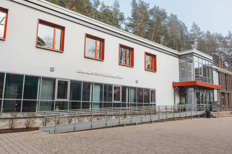 Jūrmalas Centrālās bibliotēkas ēka ar ieeju un lēzenu pandusu.
