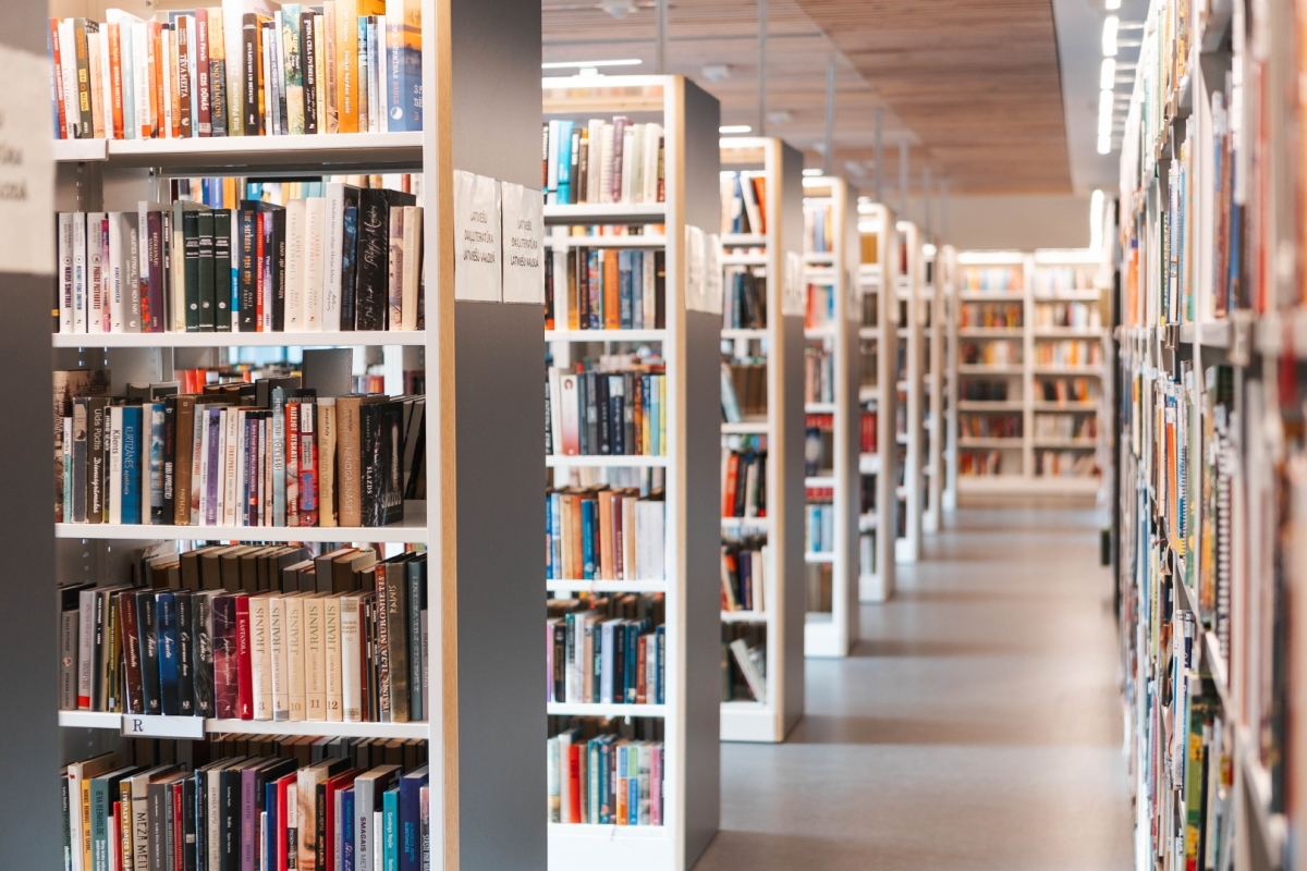 Grāmatu plaukti Jūrmalas Centrālajā bibliotēkā. Priekšplānā un tālumā redzamas plauktu rindas ar grāmatām un eja starp tām